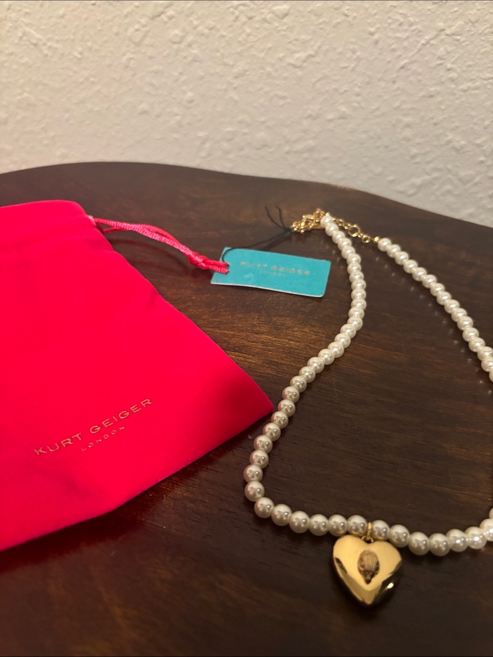 Necklace on wooden surface with pouch Kurt Geiger